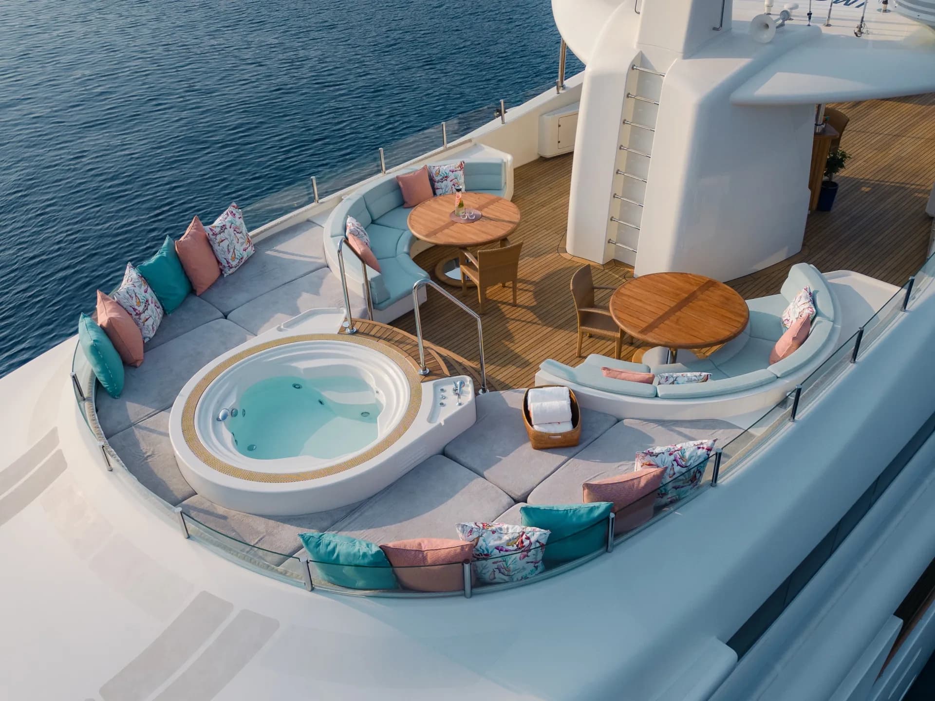 HANA's sundeck from above — jacuzzi, curved seating and teak dining tables