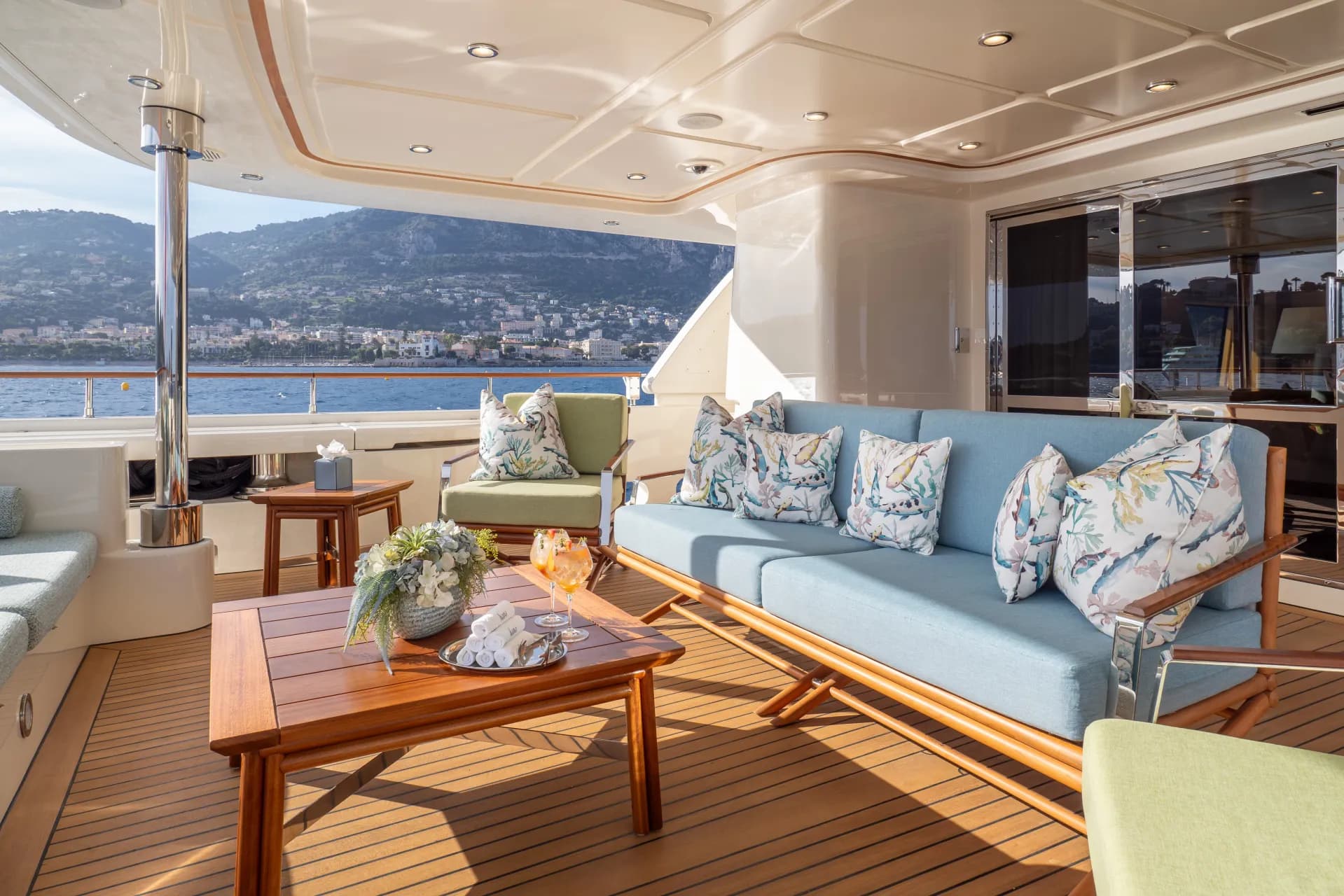 HANA's shaded bridge-deck aft lounge with sofas and teak coffee table